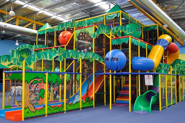 A side view of a large indoor kids playground.