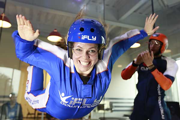 Young woman smiling whilst indoor skydiving