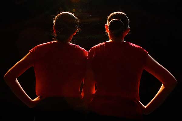 young women on stage backlit
