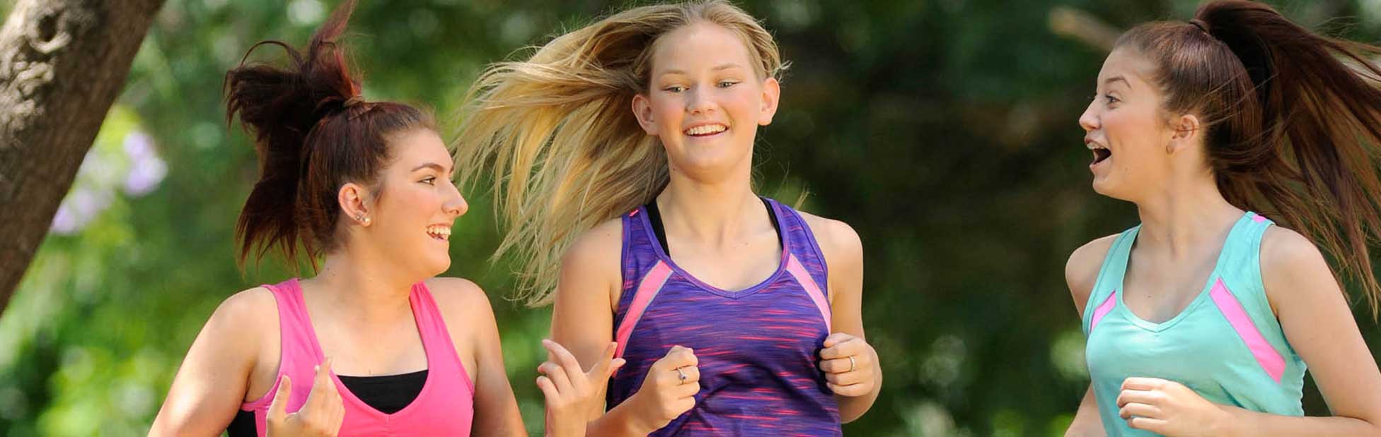 Three young women in jogging gear on Nepean River Parkrun