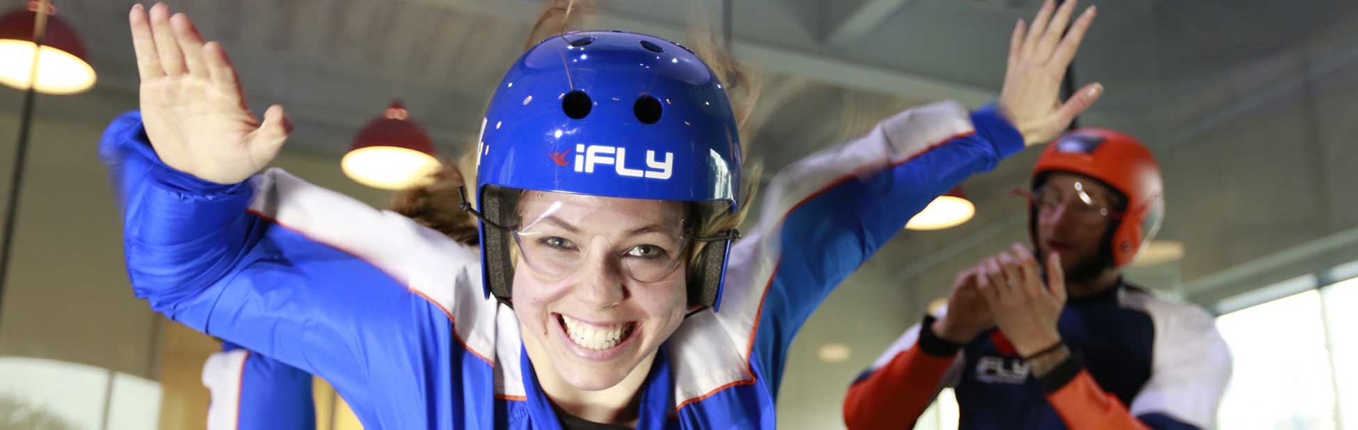 Young lady suspended in the air whilst indoor sky diving