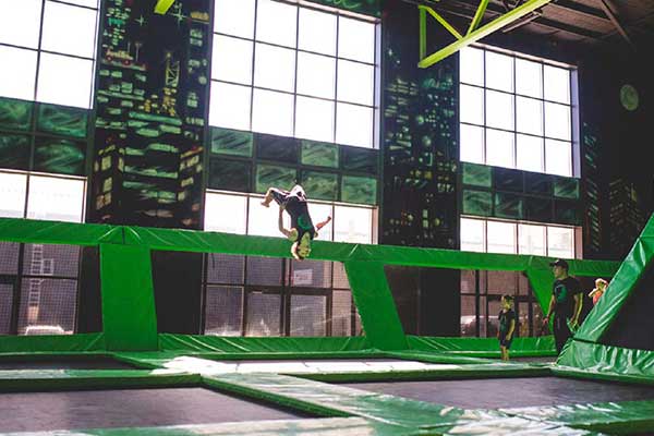 Kids jumping around on trampolines inside an indoor playground