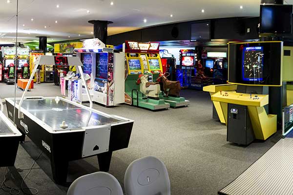 A large room filled with arcade games, pinball machines and air hockey tables