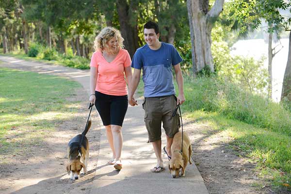 Young couple walking their dogs along the Great Nepean River Walk footpath